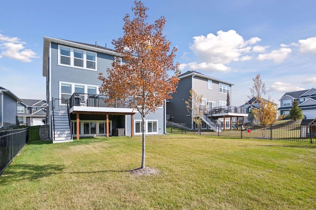 back of house featuring a deck, a fenced backyard, stairs, a yard, and a residential view