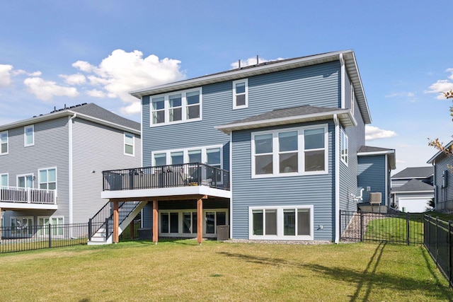 rear view of house with a fenced backyard, stairs, a lawn, and a wooden deck