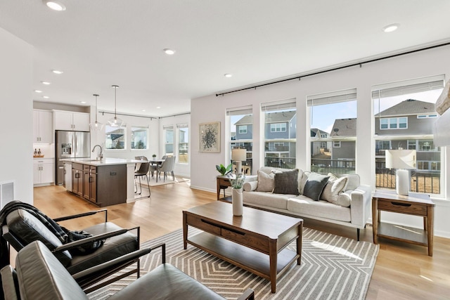 living area with recessed lighting, plenty of natural light, and light wood-style floors