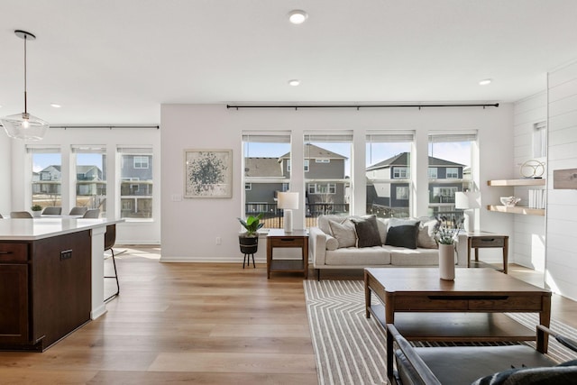 living room with baseboards, recessed lighting, and light wood-style floors