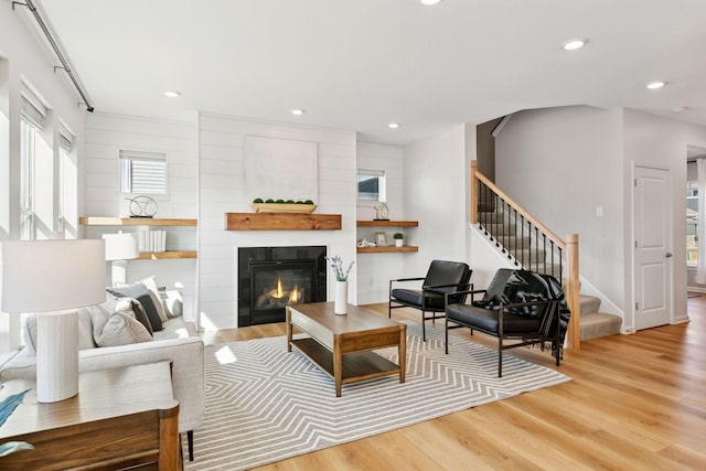 living room with a fireplace, stairway, wood finished floors, and recessed lighting