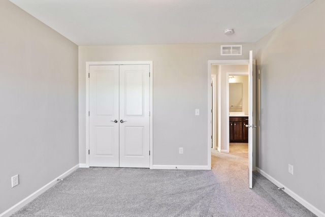 unfurnished bedroom featuring carpet floors, a closet, visible vents, and baseboards