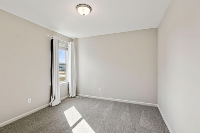 unfurnished room featuring carpet flooring and baseboards