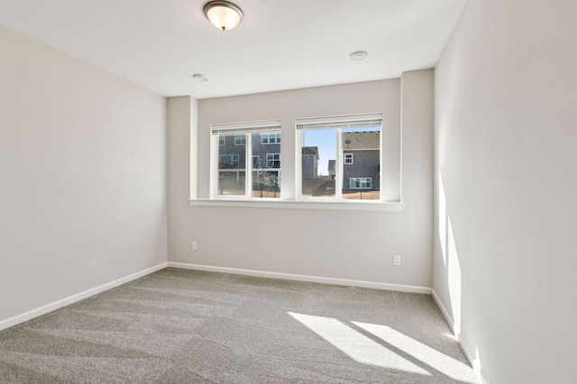 unfurnished room with carpet flooring and baseboards