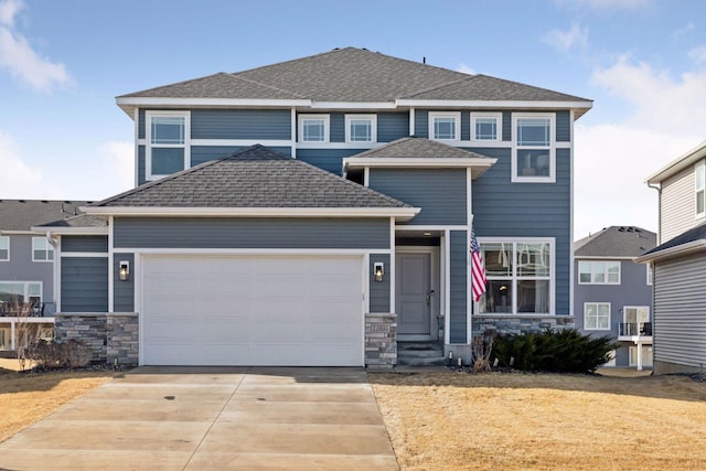 view of front of home with an attached garage, stone siding, a shingled roof, and concrete driveway