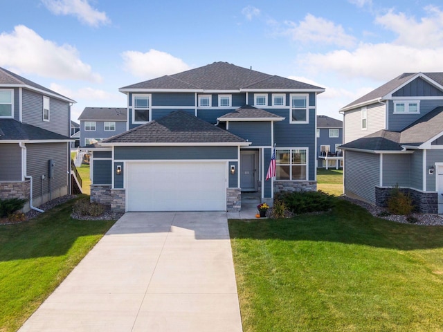 view of front of property with a garage, driveway, a front lawn, and stone siding