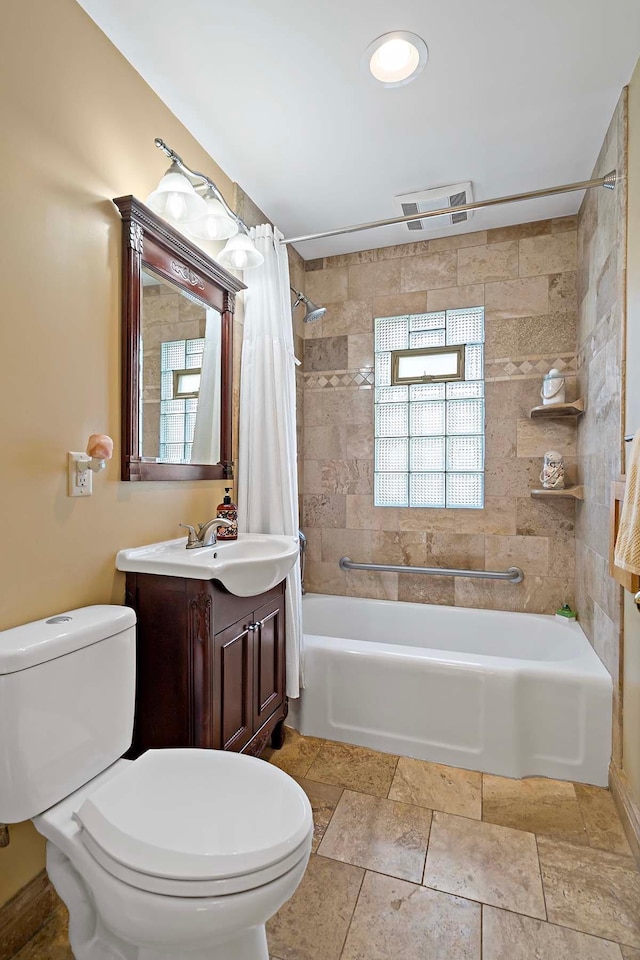 full bathroom featuring vanity, shower / bath combo, and toilet