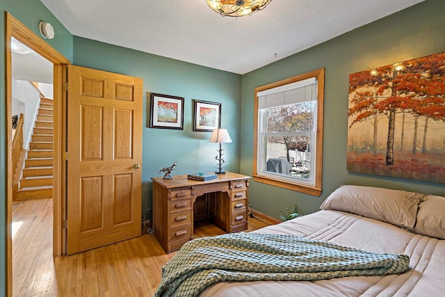 bedroom featuring a textured ceiling and light wood-type flooring