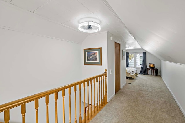 hall with lofted ceiling and light colored carpet