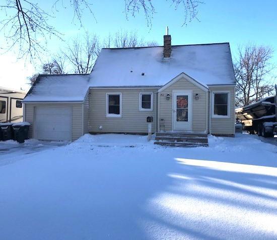 snow covered house with a garage