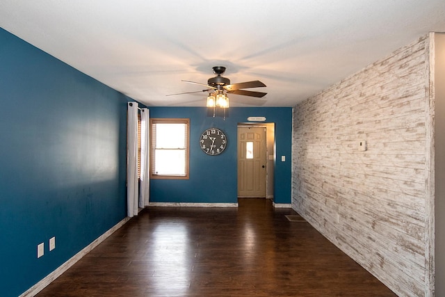 empty room featuring ceiling fan and dark hardwood / wood-style flooring