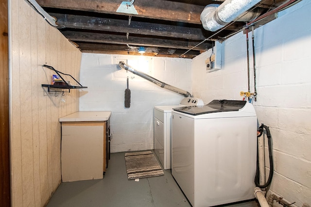 washroom with separate washer and dryer and wood walls