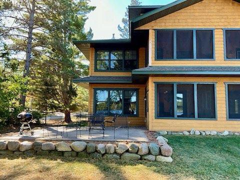 rear view of property featuring a patio and a yard