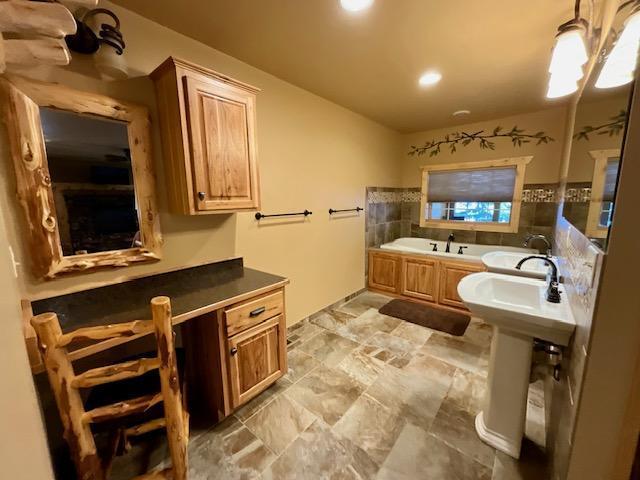 bathroom with a garden tub and recessed lighting