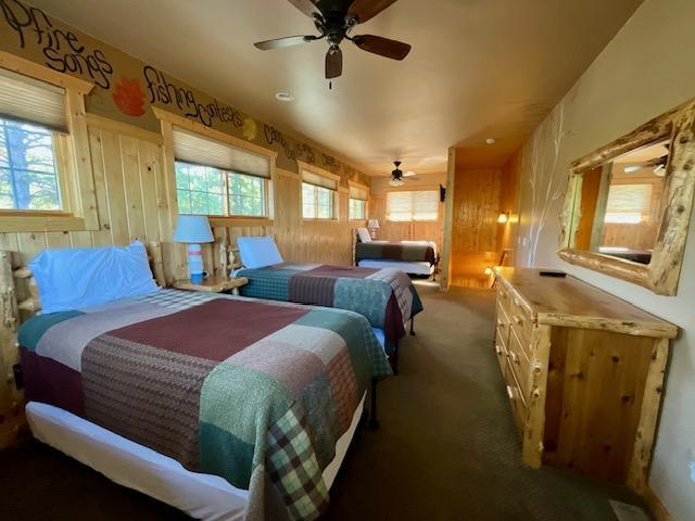 carpeted bedroom featuring wood walls