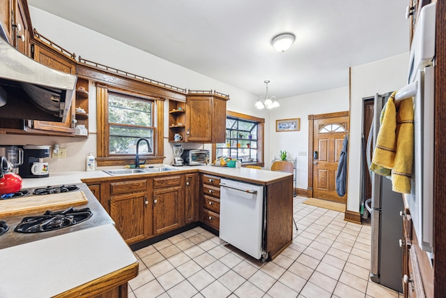 kitchen with kitchen peninsula, a healthy amount of sunlight, dishwasher, and pendant lighting