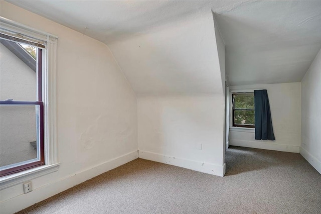 bonus room featuring carpet, vaulted ceiling, and a healthy amount of sunlight