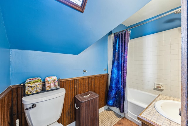 full bathroom featuring lofted ceiling with skylight, wooden walls, shower / tub combo with curtain, and toilet