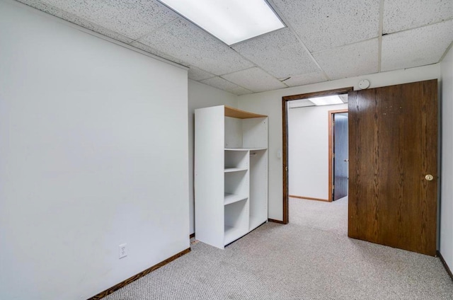 interior space featuring a drop ceiling and light colored carpet