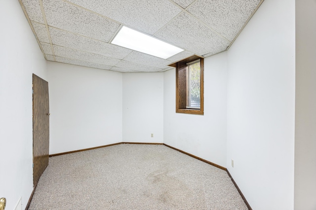 spare room featuring a drop ceiling and carpet floors