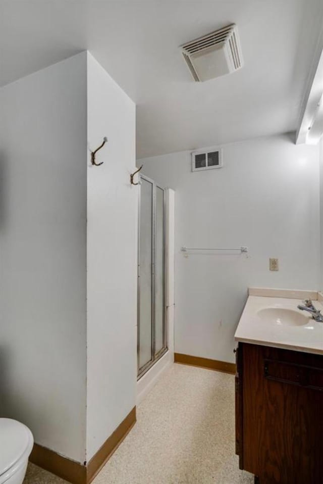 bathroom featuring a shower with door, toilet, and vanity