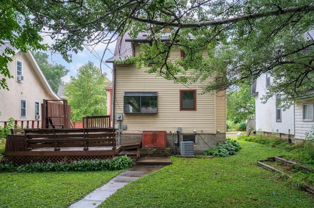 back of property with a yard, cooling unit, and a wooden deck