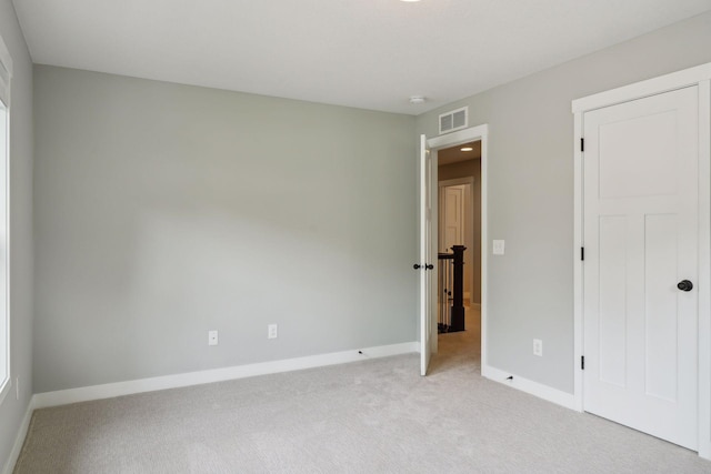 unfurnished bedroom with light colored carpet