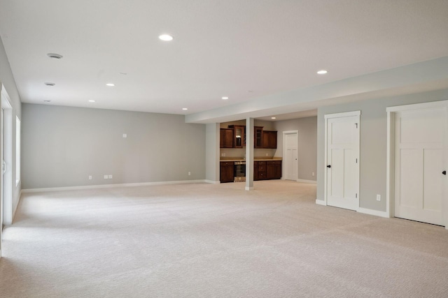 unfurnished living room with wine cooler and light colored carpet