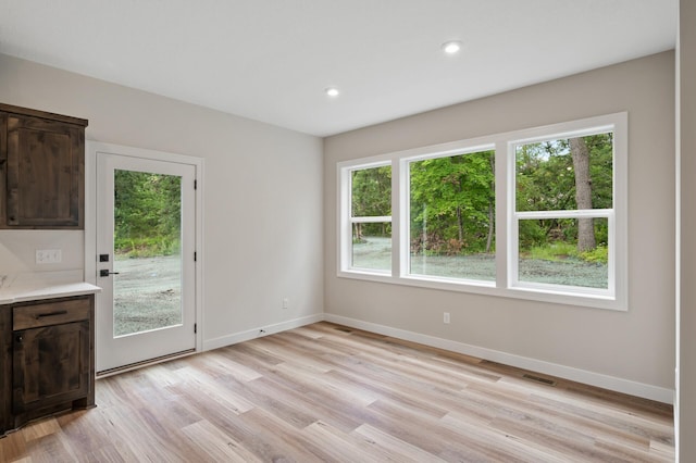 unfurnished dining area with a healthy amount of sunlight and light hardwood / wood-style flooring