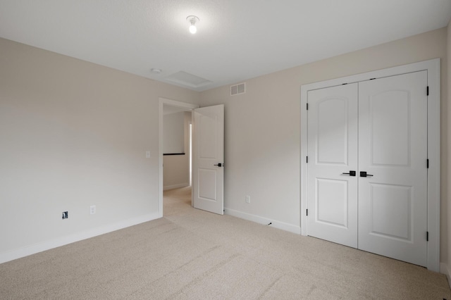 unfurnished bedroom featuring a closet and light colored carpet