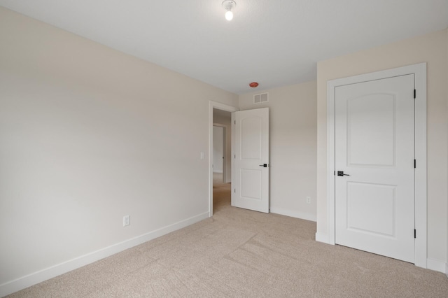 unfurnished bedroom featuring light carpet