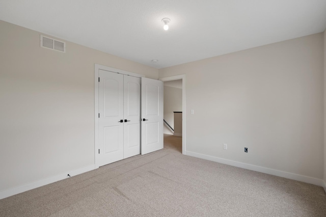 unfurnished bedroom featuring a closet and light carpet