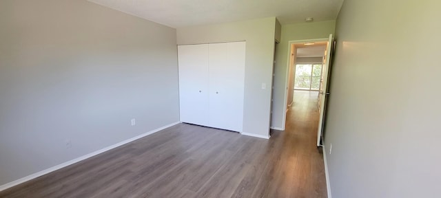 unfurnished bedroom with a closet and hardwood / wood-style flooring