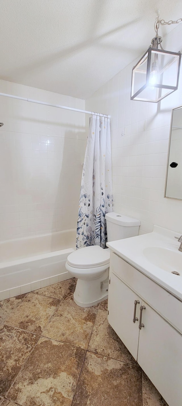 full bathroom with vanity, toilet, shower / bath combo with shower curtain, and a textured ceiling