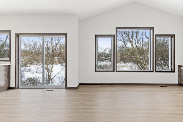 unfurnished room featuring light hardwood / wood-style floors and lofted ceiling