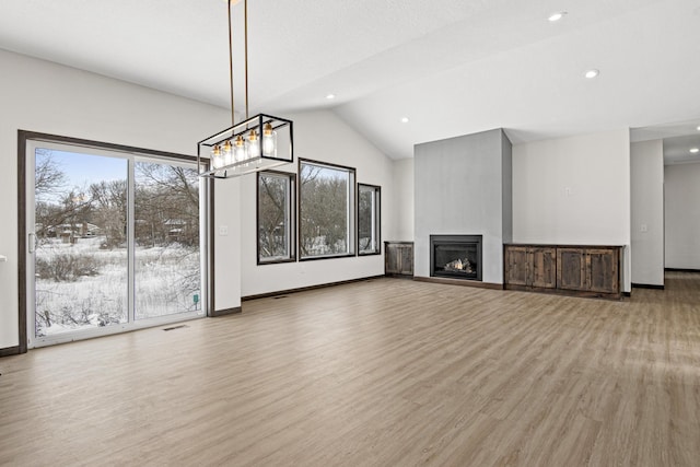 unfurnished living room with light hardwood / wood-style floors, lofted ceiling, and a fireplace