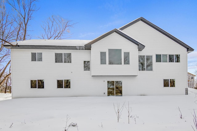 snow covered rear of property with a patio