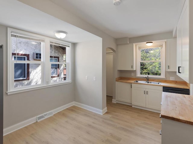 kitchen featuring light hardwood / wood-style floors, white cabinetry, sink, and plenty of natural light