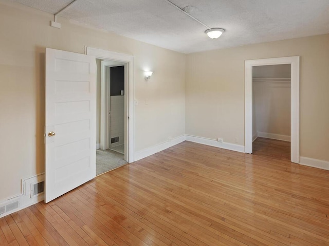 empty room featuring light hardwood / wood-style flooring and a textured ceiling