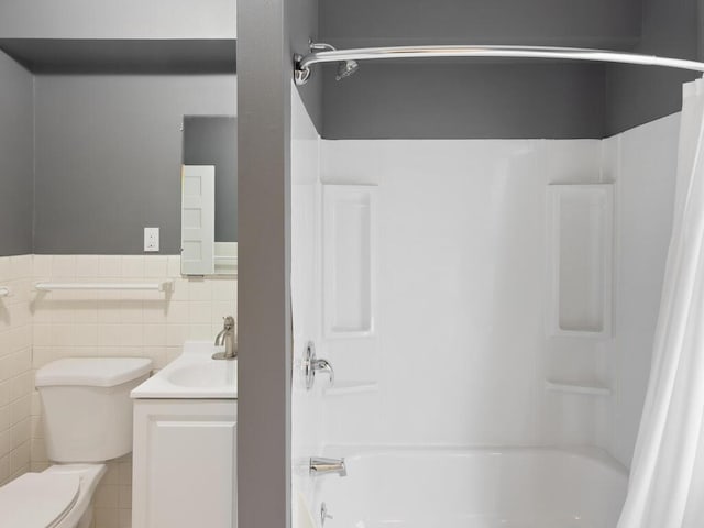 full bathroom featuring vanity, tile walls, toilet, and shower / bathtub combination with curtain