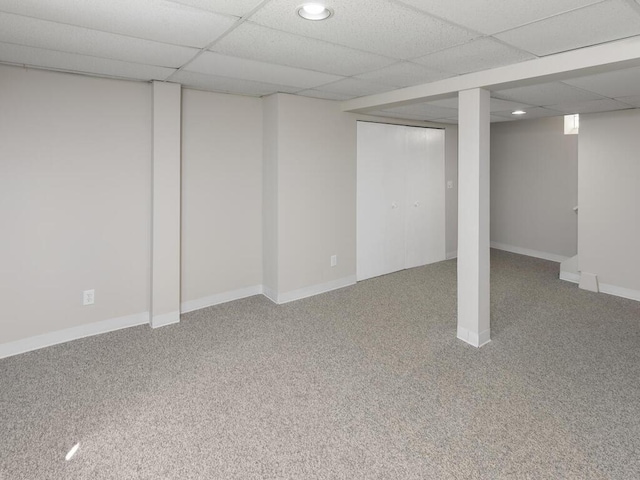 basement with a paneled ceiling and carpet floors