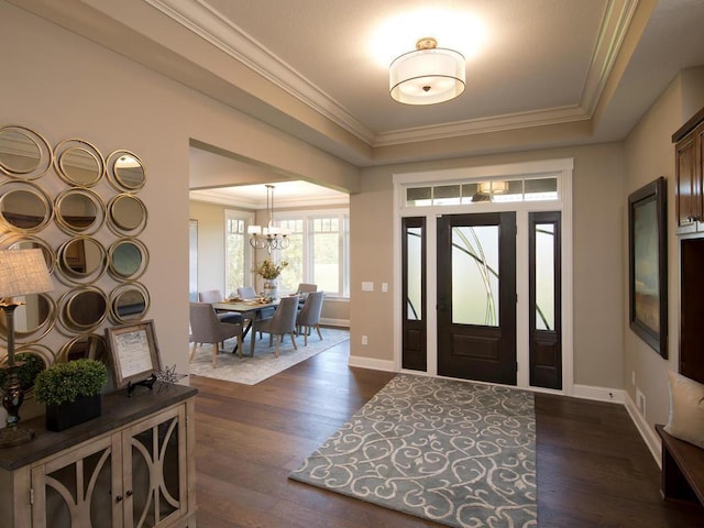 entrance foyer featuring crown molding, a notable chandelier, and dark hardwood / wood-style flooring