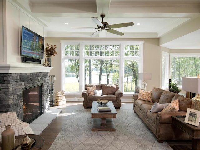 living room featuring ceiling fan, a wealth of natural light, light wood-type flooring, and a fireplace