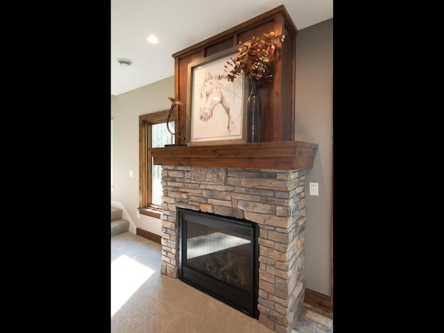 interior details with a stone fireplace and carpet floors