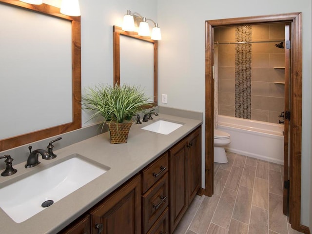 full bathroom with vanity, tiled shower / bath combo, and toilet