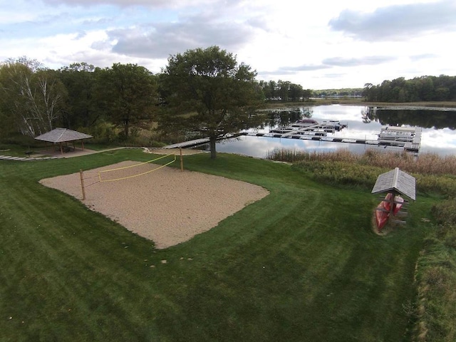 surrounding community with a lawn, a water view, and volleyball court