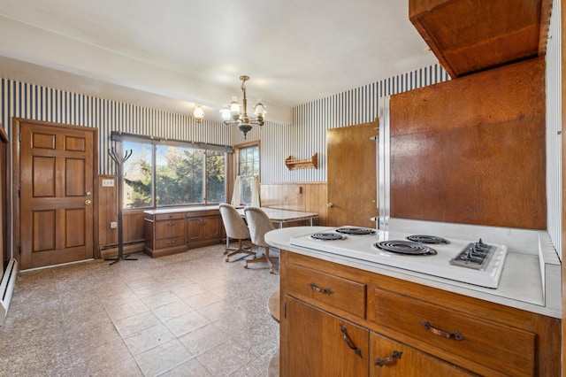 kitchen with baseboard heating, a chandelier, hanging light fixtures, and white stovetop