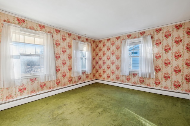 carpeted empty room with a baseboard heating unit