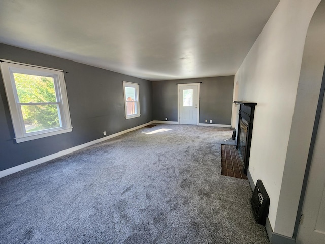 unfurnished living room featuring dark colored carpet