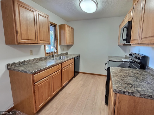 kitchen featuring sink, black appliances, a textured ceiling, and light wood-type flooring